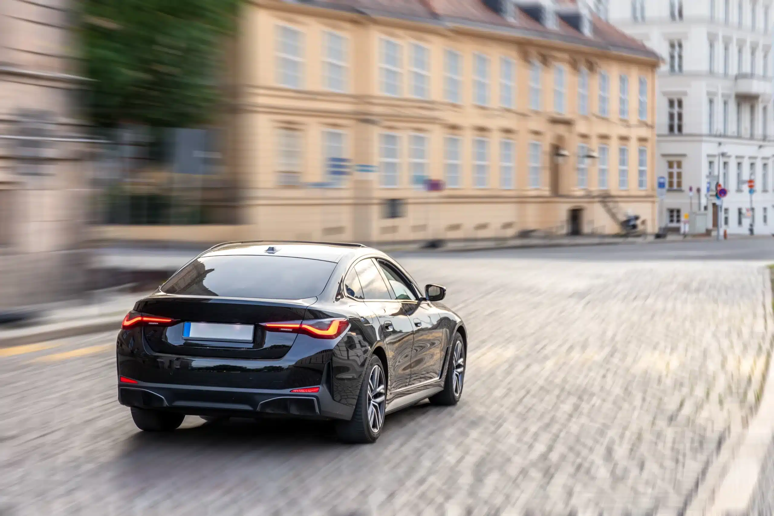 Conduite sur autoroute : voyage et coucher de soleil doré. Mains sur le volant d'une voiture, conduisant sur l'autoroute au coucher du soleil. Le soleil brille fortement à travers le pare-brise.
