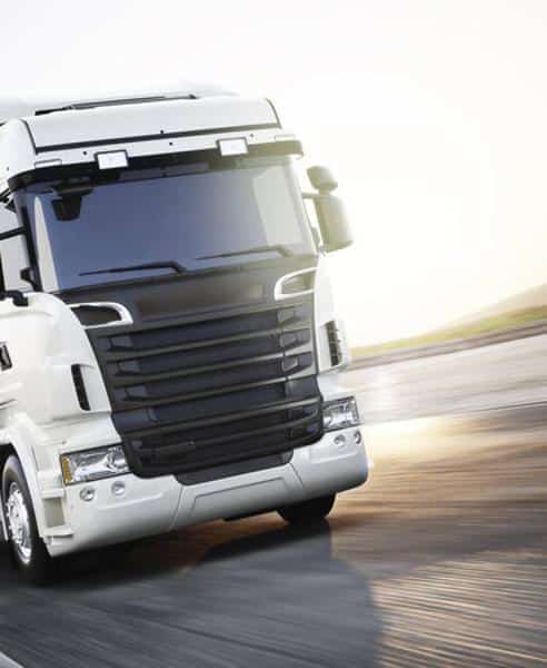 Camion de transport : vitesse et logistique moderne. Camion de transport blanc moderne roulant à grande vitesse sur une autoroute ensoleillée. Flou de mouvement dynamique.